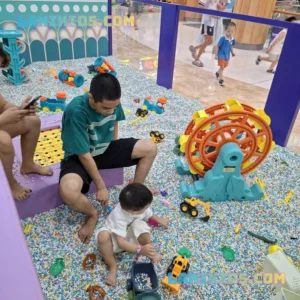 Trẻ em chơi đồ chơi máy xúc tại khu vực hạt nhựa